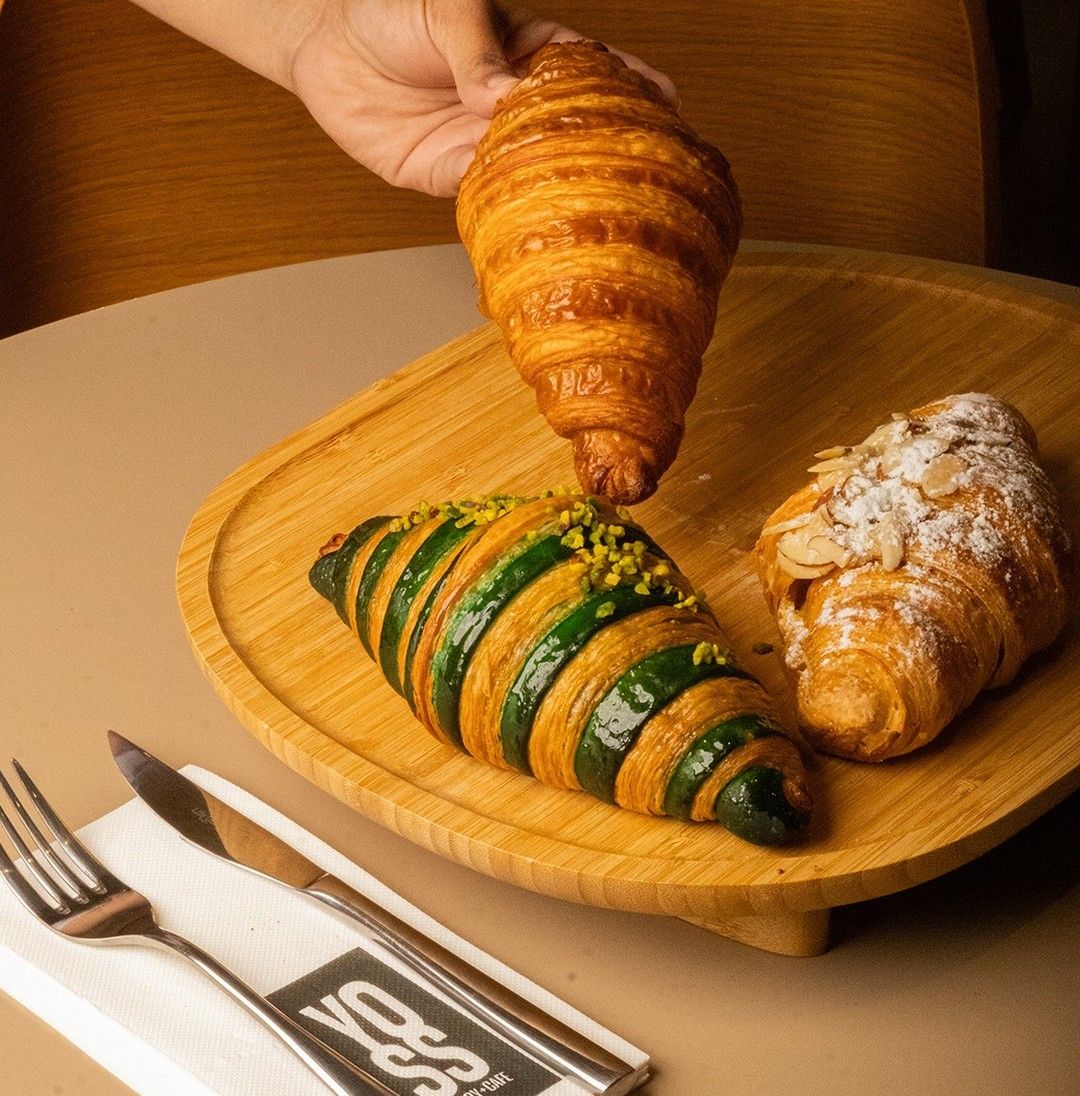 Croissants artesanales de Yoss Bakery sobre tabla de madera